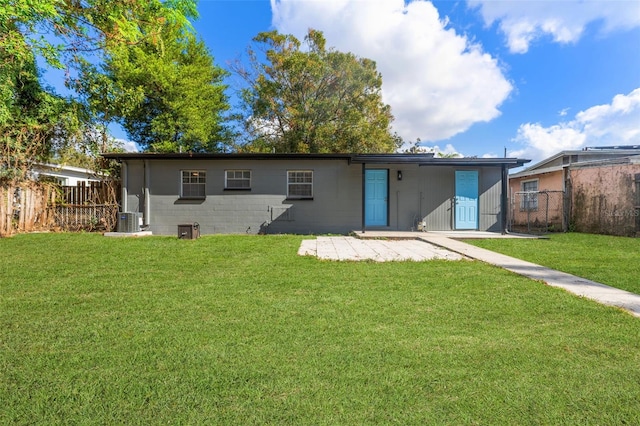 back of property with a yard and central AC unit