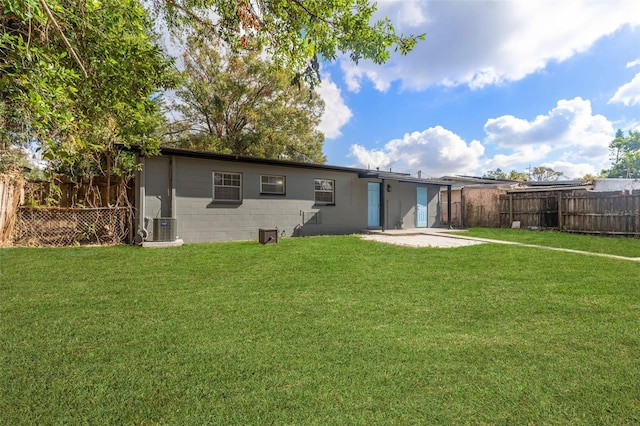 back of house with a lawn, central air condition unit, and a patio area