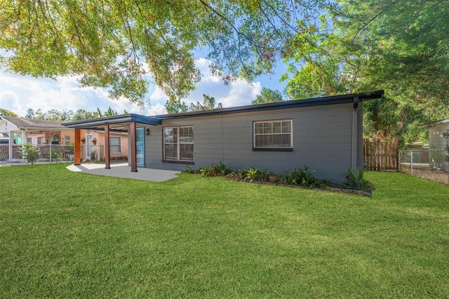 back of property with a lawn and a patio area