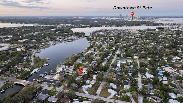 aerial view at dusk featuring a water view