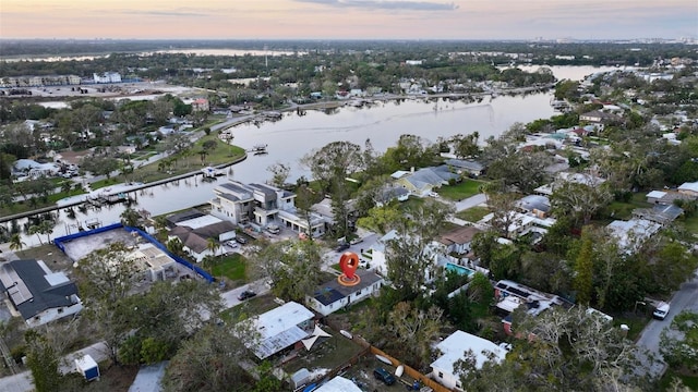 aerial view at dusk featuring a water view