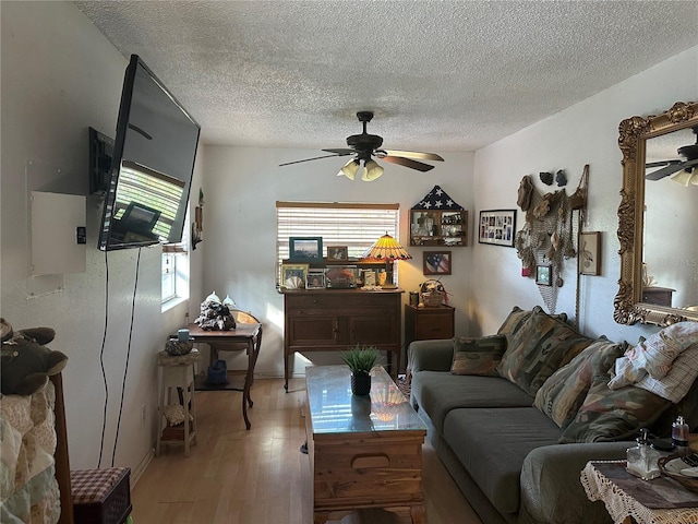 living room with ceiling fan, light hardwood / wood-style floors, a textured ceiling, and a wealth of natural light