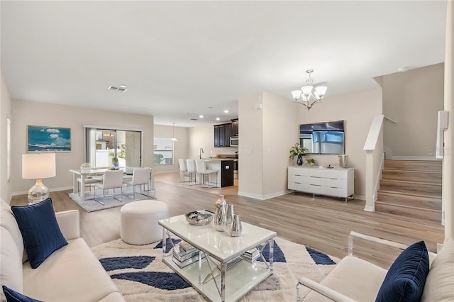 living room featuring a chandelier and light hardwood / wood-style flooring