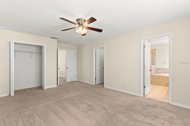 unfurnished bedroom featuring ensuite bathroom, ceiling fan, and light colored carpet