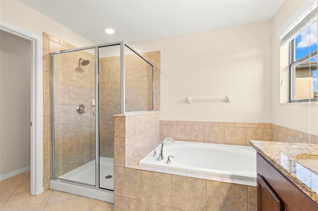 bathroom with tile patterned flooring, shower with separate bathtub, and vanity