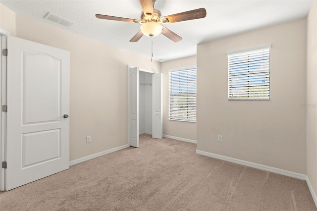 unfurnished bedroom featuring ceiling fan and light carpet