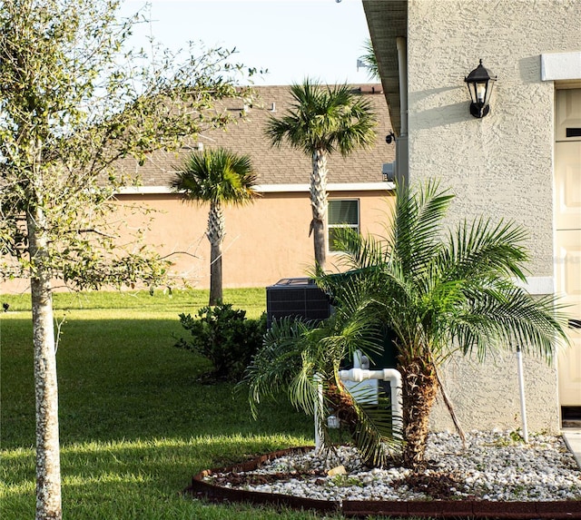 view of home's exterior featuring central air condition unit and a yard