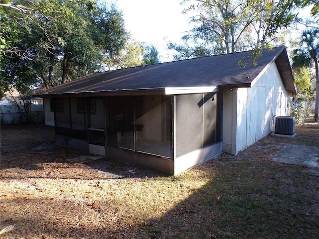 back of property with central air condition unit and a sunroom