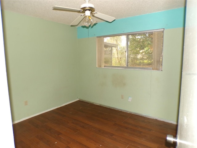 empty room with a textured ceiling, dark hardwood / wood-style flooring, and ceiling fan