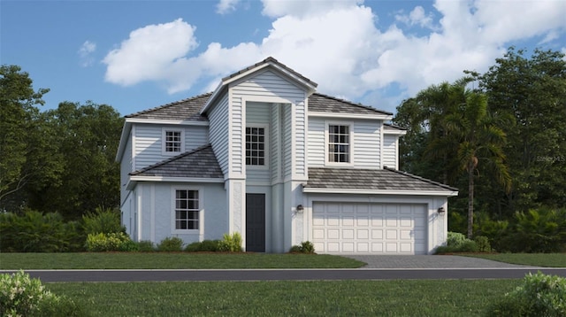 view of property featuring a garage and a front lawn