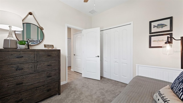 bedroom with ceiling fan, a closet, and light colored carpet