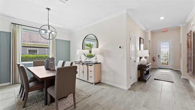 dining space with ornamental molding and a chandelier