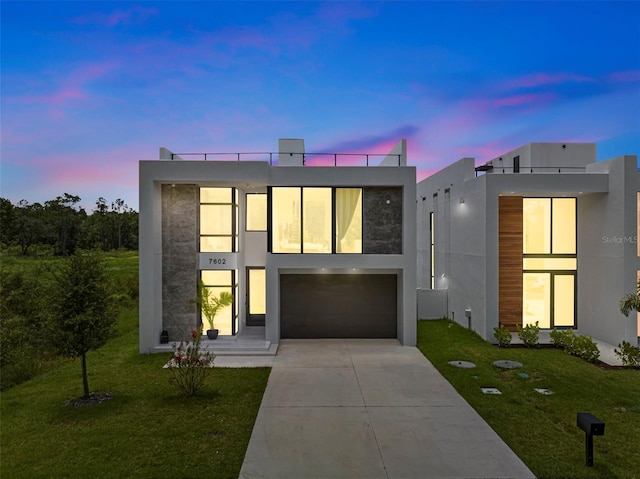 contemporary house with stucco siding, driveway, and a front lawn