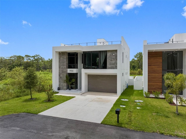 modern home with stucco siding, concrete driveway, and a front lawn