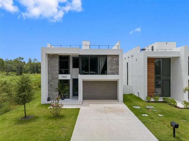 contemporary home with stucco siding, concrete driveway, and a front yard