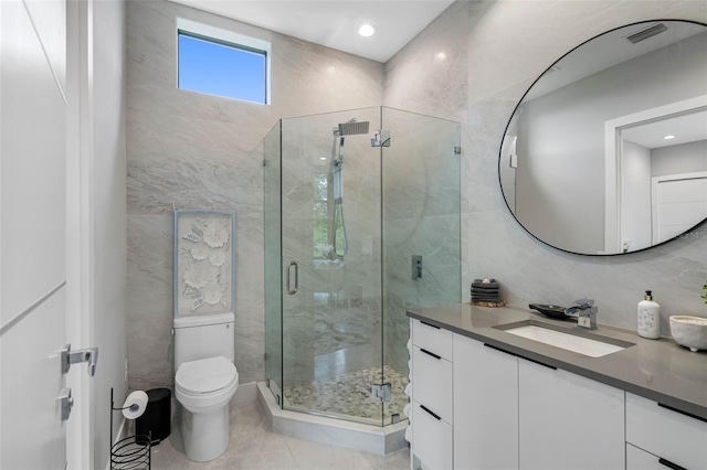 full bath with tile walls, a stall shower, toilet, and vanity