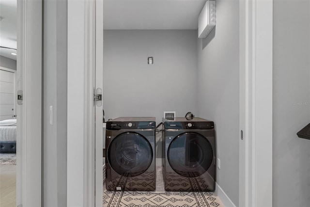 laundry room with washer and dryer, light tile patterned floors, and baseboards