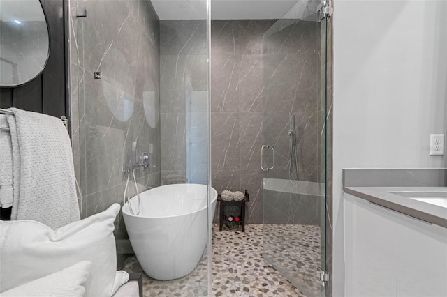 bathroom with a soaking tub, a shower stall, and vanity