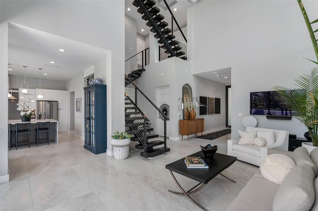 living room featuring stairway, recessed lighting, and a towering ceiling