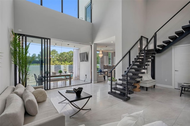 interior space featuring a high ceiling, stairs, and baseboards