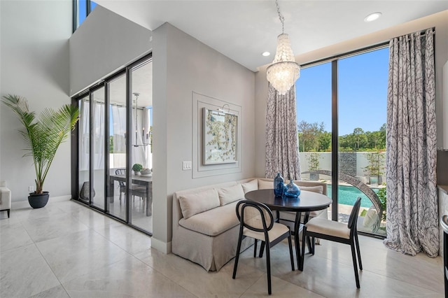 dining room featuring a chandelier, recessed lighting, and baseboards