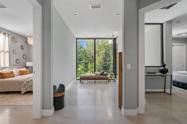 corridor featuring floor to ceiling windows, recessed lighting, baseboards, and visible vents