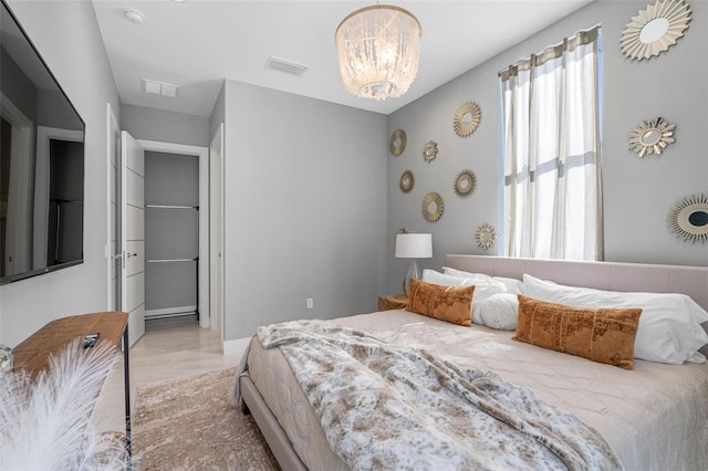 bedroom featuring visible vents, light wood-style floors, and an inviting chandelier