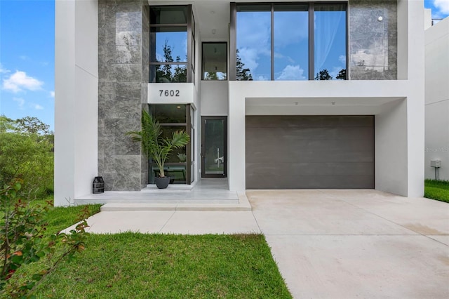 entrance to property with concrete driveway and stucco siding