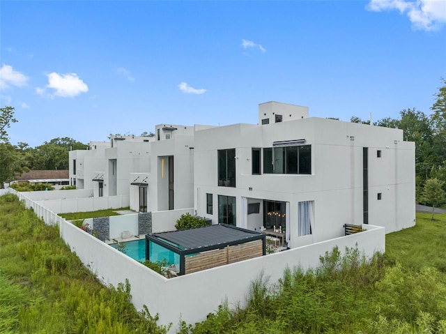 back of house featuring stucco siding and fence