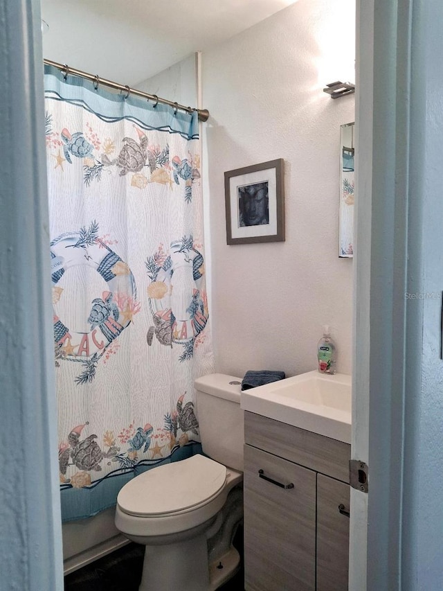 bathroom with toilet, vanity, and a shower with curtain