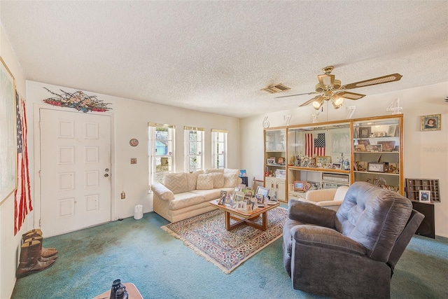 living room with ceiling fan, carpet, and a textured ceiling