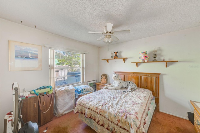 bedroom with ceiling fan, carpet floors, and a textured ceiling