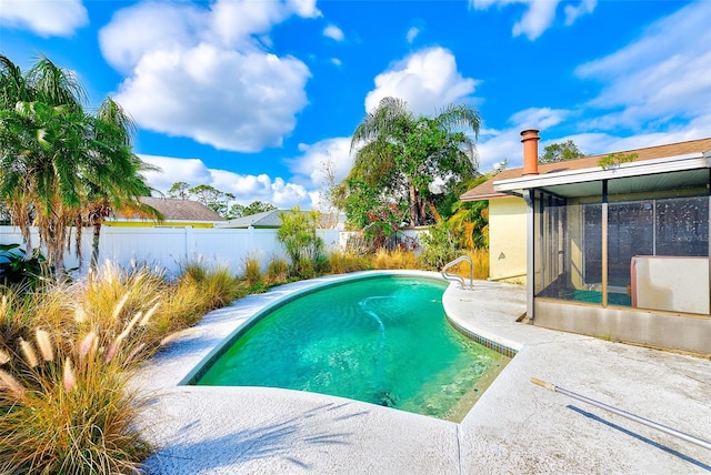 view of pool with a sunroom and a patio