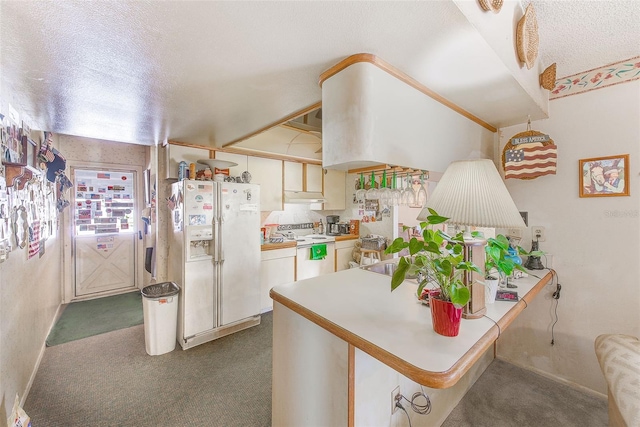 kitchen with cream cabinets, range with electric stovetop, white fridge with ice dispenser, kitchen peninsula, and a breakfast bar area