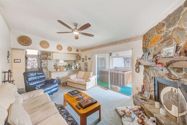 living room featuring carpet, a textured ceiling, vaulted ceiling, ceiling fan, and a fireplace