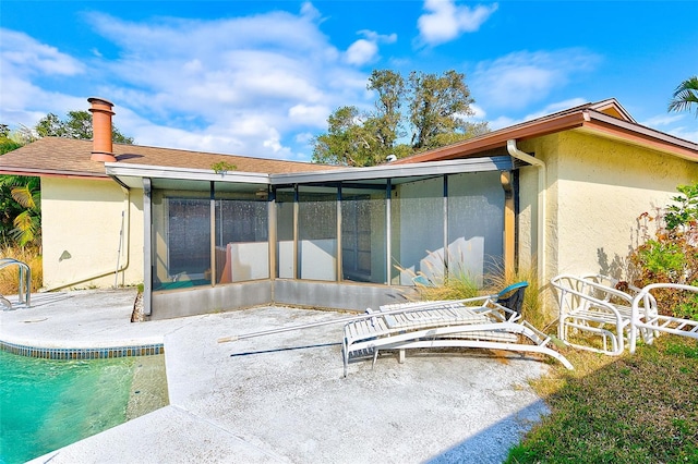 view of pool featuring a sunroom and a patio