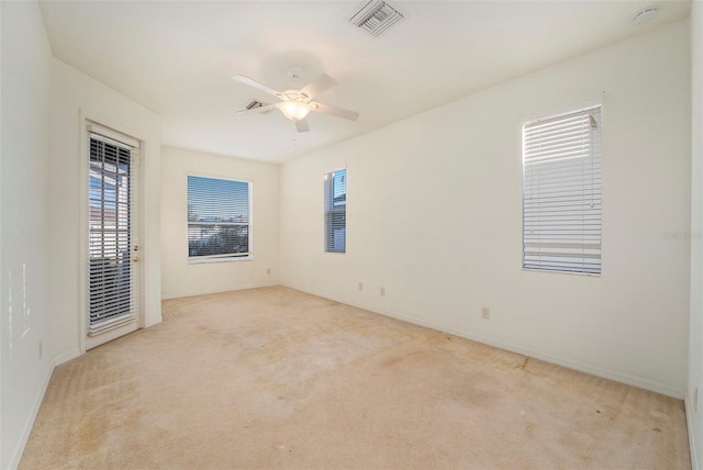 empty room with ceiling fan and light colored carpet