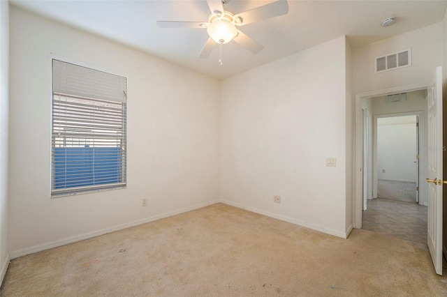 carpeted spare room with ceiling fan