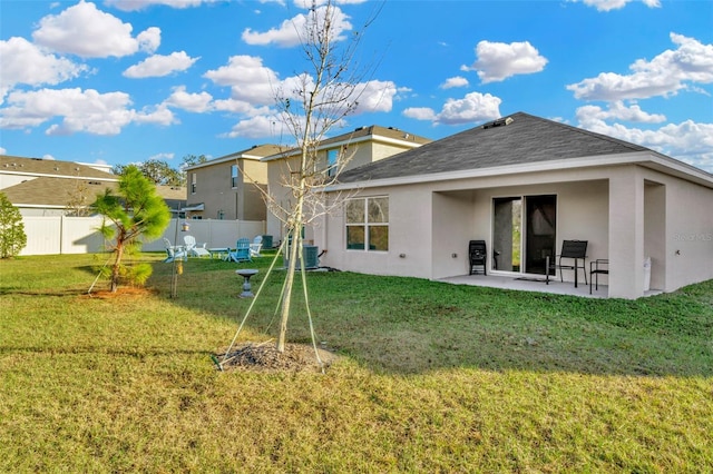 back of property with a yard, a patio, and central AC