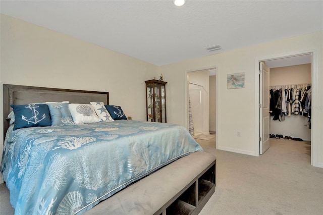 bedroom featuring a spacious closet, a closet, and light carpet