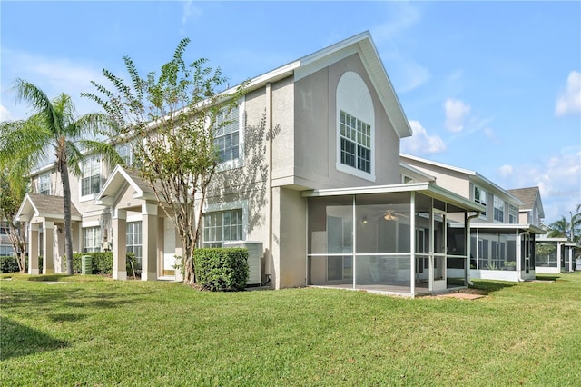 rear view of property with a sunroom and a lawn