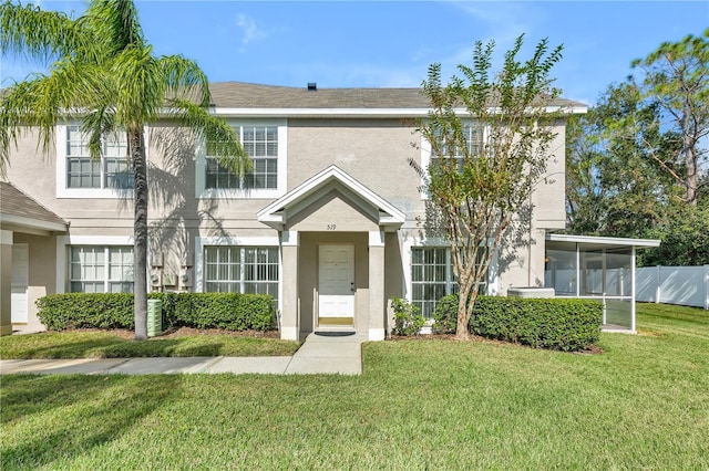 view of front of property featuring a sunroom and a front lawn