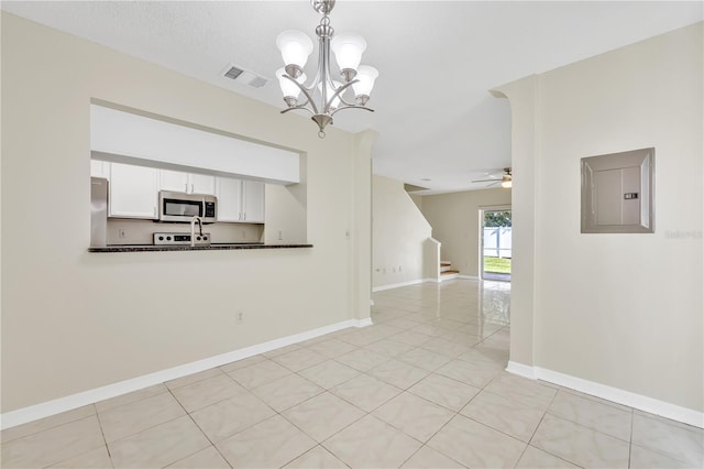 interior space featuring ceiling fan with notable chandelier, electric panel, and light tile patterned flooring