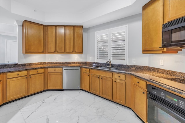 kitchen featuring dark stone counters, a raised ceiling, sink, and black appliances