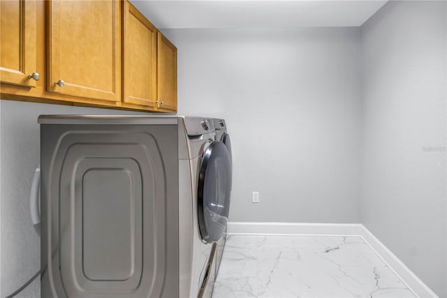 laundry room featuring cabinets and washing machine and clothes dryer