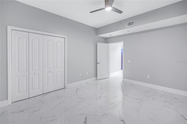 unfurnished bedroom with ceiling fan and a closet