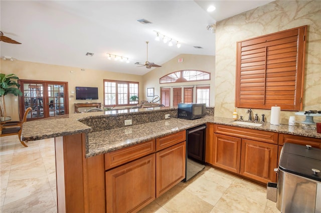 kitchen with kitchen peninsula, vaulted ceiling, ceiling fan, sink, and black appliances