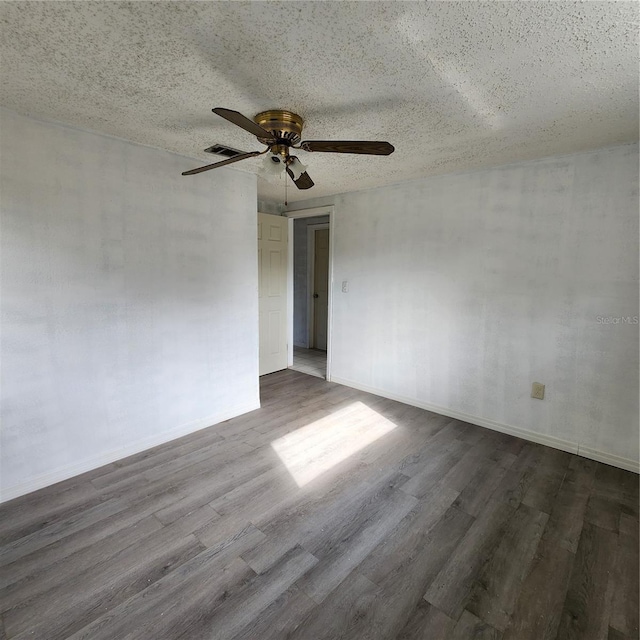 empty room with a textured ceiling, hardwood / wood-style flooring, and ceiling fan