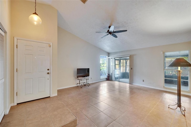 unfurnished living room featuring light tile patterned flooring, high vaulted ceiling, a textured ceiling, and ceiling fan