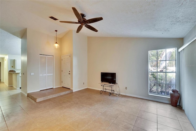 unfurnished living room with ceiling fan, high vaulted ceiling, light tile patterned floors, and a textured ceiling